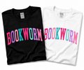 Folded black and white Gildan T-shirts with “BOOKWORM” in pink, purple, and turquoise varsity lettering.